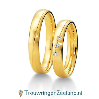 Trouwringen in 8*/14/18 karaat geelgoud mat en glans golvend over de ring met in de damesring 3 diamanten per paar