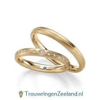 Trouwringen in 14/18 karaat geelgoud mat met midden groef glans en in de damesring 1 grote en aan weerszijden 5 kleinere diamanten