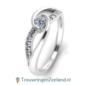 Verlovingsring in platina 950 met een grote diamant als middensteen en 12 diamanten golvend er omheen