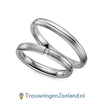 Trouwringen in platina 600/950 mat en glans 3,0 mm. breed met 2 golven en in de damesring  1 diamant 0,03 ct 
