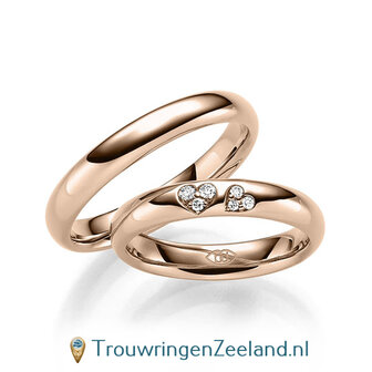 Trouwringen in 14/18 karaat roodgoud glans gepolijst met in de damesring 6 diamanten in 2 hartjes gezet 0,065 ct 