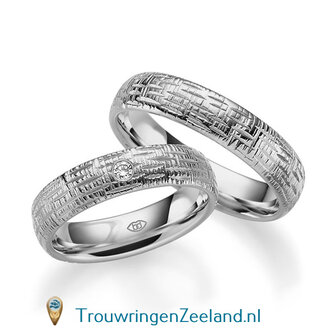Trouwringen in 14/18 karaat witgoud glans horizontale en verticale groefjes 5,0 mm. breedte en in de damesring 1 diamant van 0,03 ct. per paar vanaf