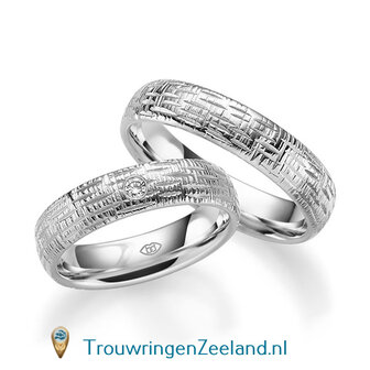 Trouwringen in 14/18 karaat witgoud glans horizontale en verticale groefjes 5,0 mm. breedte en in de damesring 1 diamant van 0,03 ct. per paar vanaf