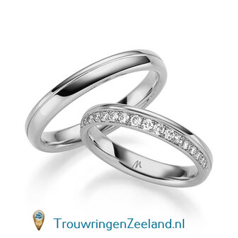 Trouwringen in 14/18 karaat witgoud glans gepolijst 3,5 mm. breed met diagonale groef en in de damesring 19 diamanten in de golf gezet per paar vanaf