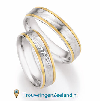 Trouwringen in zilver met golven mat met 14 karaat geelgoud zijbanen glans gepolijst en 3 diamanten schuin gezet per paar 