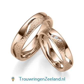 Trouwringen in 8, 14 of 18 karaat witgoud glans gepolijst en gehamerd mat 5,0 mm. breedte met 5 open golven en in de damesring 3 diamanten per paar 