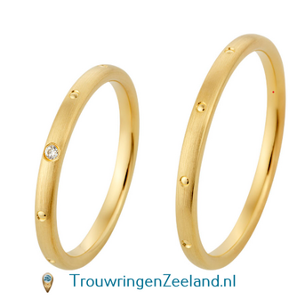 Trouwringen in 8*/14/18 karaat geelgoud met bewerking langs mat met dots verdeeld over de ringen en in de damesring 1 diamant gezet