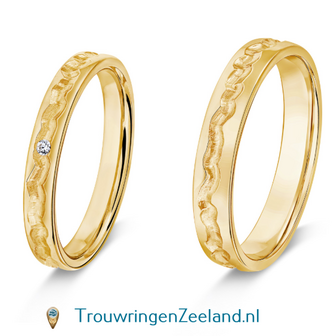 Trouwringen in 8*/14/18 karaat geelgoud middenbaan hamerslag grof glans en zijkanten glans gepolijst met in de damesring 1 diamant