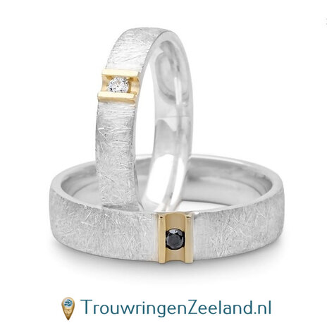 Trouwringen in argentium ijsmat en 14 karaat geelgoud glans in damesring een witte en in herenring zwarte diamant per paar 