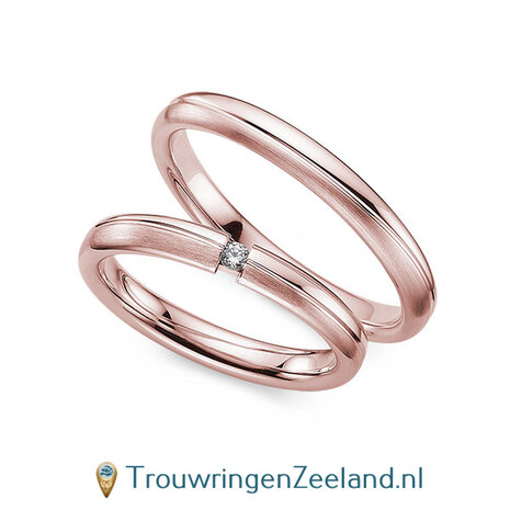 Trouwringen in 14/18 karaat roségoud mat en glans 3,0 mm. breed met 2 golven en in de damesring  1 diamant 0,03 ct 