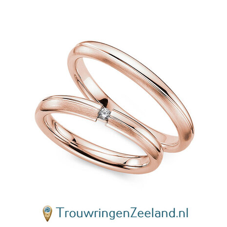Trouwringen in 14/18 karaat roségoud mat en glans 3,0 mm. breed met 2 golven en in de damesring  1 diamant 0,03 ct 