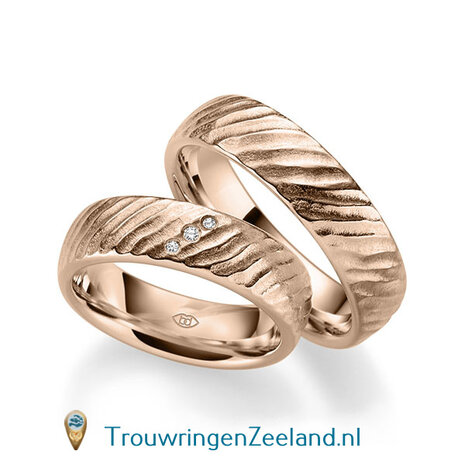 Trouwringen in 14 of 18 karaat geelgoud mat met schuine rillen 6,0 mm. breedte en in de damesring 3 diamanten schuin gezet per paar 