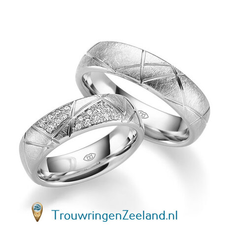 Trouwringen in 14 of 18 karaat witgoud ijsmat met schuine groeven 6,0 mm. breedte en in de damesring 17 diamanten in designzetting per paar 