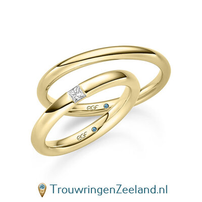 Trouwringen in 14/18 karaat geelgoud glad glans en in de damesring 1 grote geklemde diamant