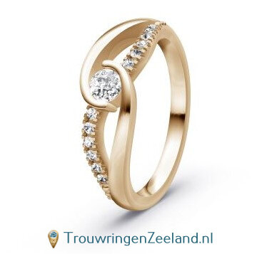 Verlovingsring 14 karaat champagne goud met een grote diamant als middensteen en 12 diamanten golvend er omheen