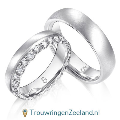 Trouwringen in 14 of 18 karaat witgoud mat met in de damesring 26 grote diamanten in de rand gezet per paar