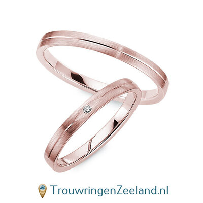 Trouwringen in 8*/14/18 karaat roodgoud mat met V-groef 2,5 mm. breed met in de damesring 1 x 0,008 ct diamant in ovalen zetting