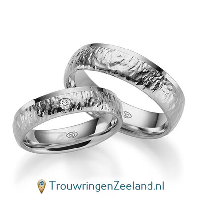 Trouwringen in platina 600/950 bewerkt en rand glans gepolijst 5 mm. breed met in de damesring 1 diamant