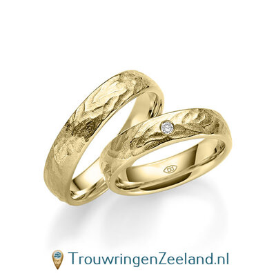 Trouwringen in 14/18 karaat geelgoud bewerkt 5 mm. breed met in de damesring 1 diamant