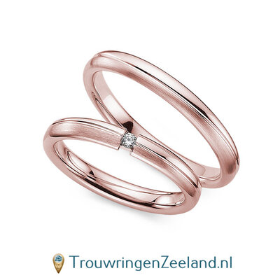 Trouwringen in 8*/14/18 karaat roodgoud mat en glans 3,0 mm. breed met 2 golven en in de damesring  1 diamant 0,03 ct