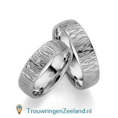 Trouwringen in platina 600/950 mat en glans 6,0 mm. breed met golven overdwars en in de damesring 3 diamanten schuin gezet per paar vanaf