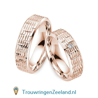 Trouwringen in 14/18 karaat roségoud glans schub structuur 6,0 mm. breedte en in de damesring 1 diamant van 0,05 ct. per paar vanaf