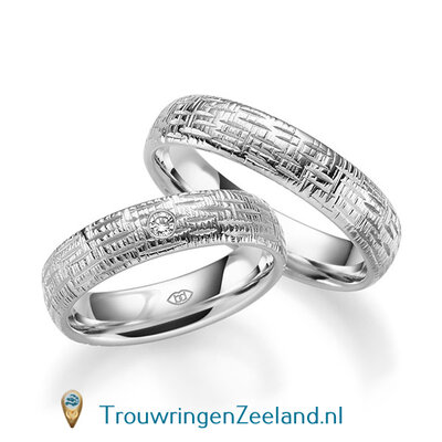 Trouwringen in 14/18 karaat witgoud glans horizontale en verticale groefjes 5,0 mm. breedte en in de damesring 1 diamant van 0,03 ct. per paar vanaf