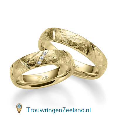 Trouwringen in 14 of 18 karaat geelgoud ijsmat met  schuine groeven 5,0 mm. breedte en in de damesring 3 diamant van 0,01 ct. per paar