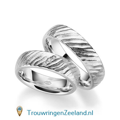 Trouwringen in 14 of 18 karaat witgoud mat met schuine rillen 6,0 mm. breedte en in de damesring 3 diamanten schuin gezet per paar