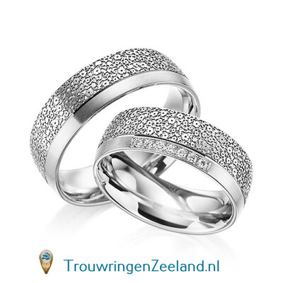Trouwringen in 14 of 18 karaat witgoud met bloemmotief mat/glans en rand glans gepolijst 7,0 mm. breedte met in de damesring 15 diamanten per paar