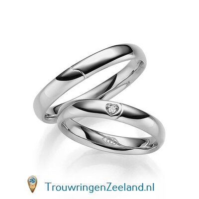 Trouwringen in 14 of 18 karaat witgoud glad gepolijst 4,0 mm. breedte met in de damesring 1 diamant in een hart gezet per paar