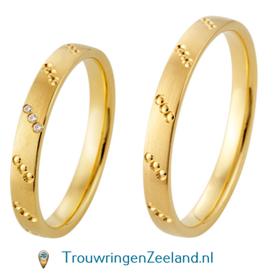 Trouwringen in 8*/14/18 karaat geelgoud met bewerking langs mat met 3 dots schuin gezet geheel rondom en in de damesring 3 diamanten schuin gezet